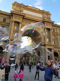 People in town square against sky in city