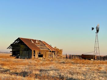 Abandoned house on field against clear sky