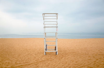 Lifeguard hut at beach against sky