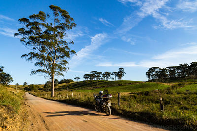 Scooter parked on country road by cultivated land