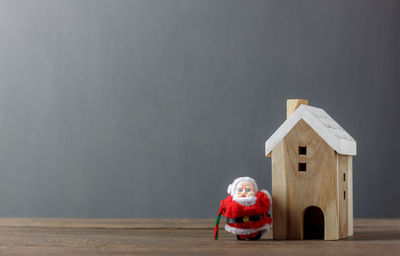 Close-up of santa claus figurine and model home on table during christmas