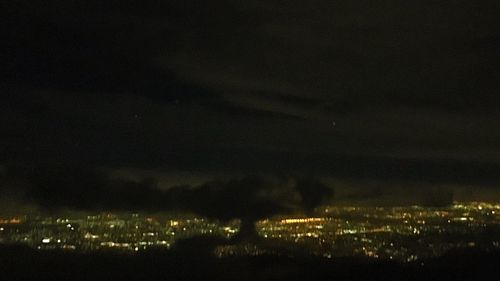 Aerial view of illuminated city against sky at night