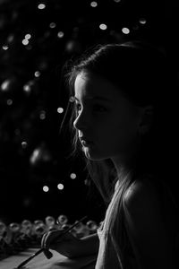 Girl looking away against sky at night