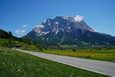 Road amidst field against sky