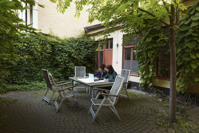 Female architects planning over laptop at table in backyard