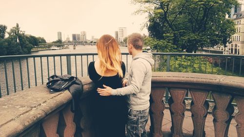 Couple by wall looking at river