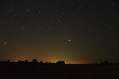 Silhouette landscape against sky at night