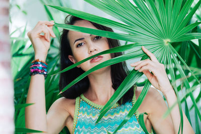 Portrait of young woman holding plant