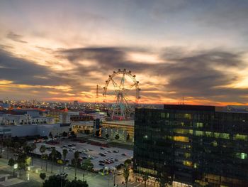 View of cityscape against cloudy sky at sunset