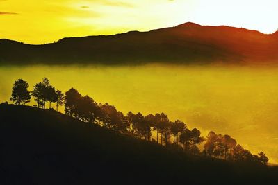 Scenic view of silhouette mountains against sky at sunset