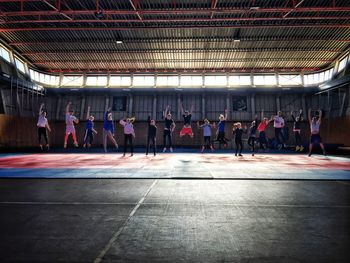 People jumping in brightly lit room