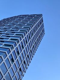 Low angle view of modern building against clear blue sky