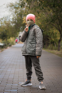 Full length of young woman walking on footpath