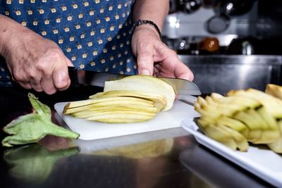 Midsection of man preparing food in kitchen at home