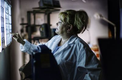 Side view of female doctor looking at medical x-ray