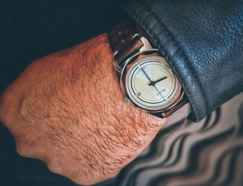 High angle view of hand holding clock