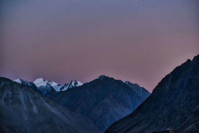 Scenic view of snowcapped mountains against sky at sunset