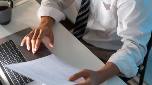 Midsection of business colleagues working on table