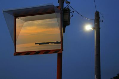 Low angle view of illuminated street light against blue sky