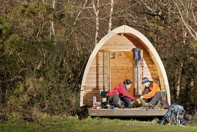 Couple preparing for a hike in front of camping pod in the uk