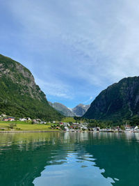 Scenic view of lake by mountains against sky