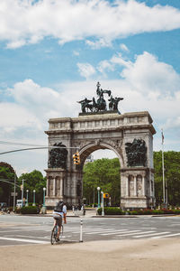 Statue in city against sky