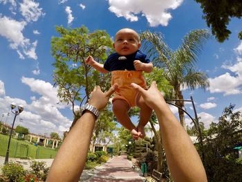 Low angle view of boy playing against blue sky