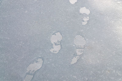 High angle view of footprints on snow covered road