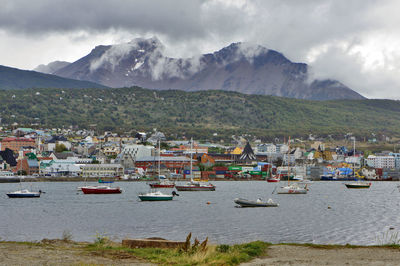 Boats in sea with town in background