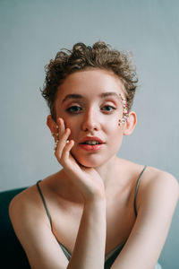 Portrait of young woman against gray background