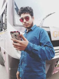 Young man photographing with mobile phone