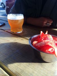 Close-up of hand holding drink on table