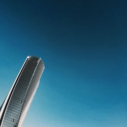 Low angle view of skyscraper against clear blue sky