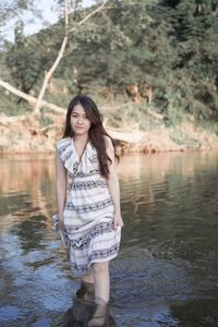 Portrait of a beautiful young woman standing in lake