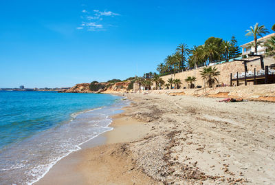 Scenic view of beach against clear blue sky