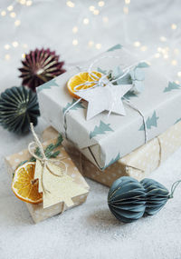 Christmas decorative homemade gift boxes wrapped in brown kraft paper on a gray concrete background