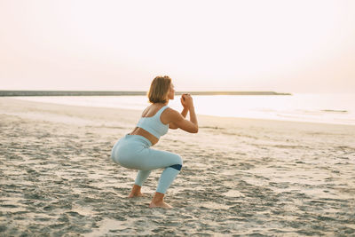 Attractive athletic woman training outdoors with a resistance elastic band. a girl in sports clothes 