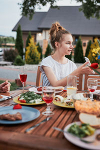 Family having a meal from grill during summer picnic outdoor dinner in a home garden