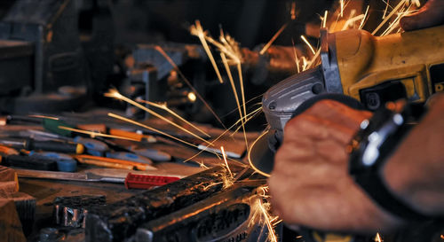 Cropped hands of male worker cutting metal in workshop