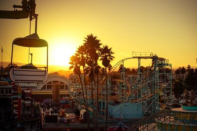 View of amusement park against sky during sunset