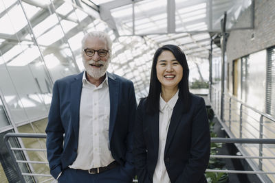 Portrait of smiling senior businessman and businesswoman in modern office building