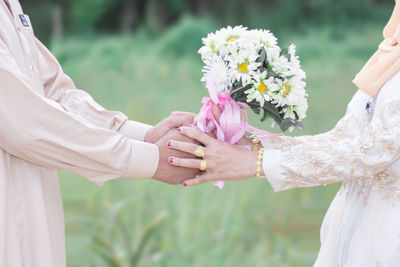 Close-up of hand holding flower bouquet