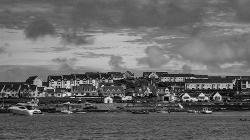 Panoramic shot of buildings by sea against sky