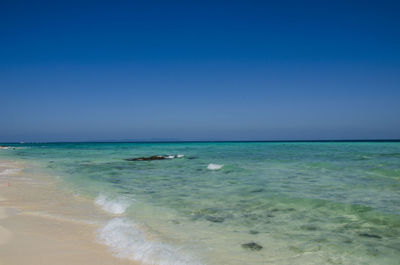 Scenic view of sea against clear blue sky