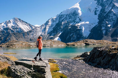 Full length of woman standing on rock against mountain