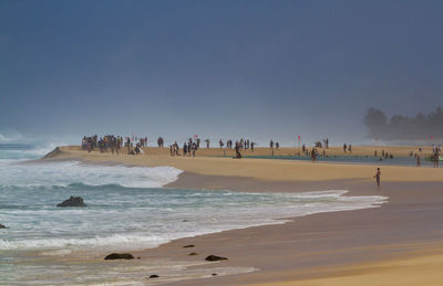 People on beach against sky