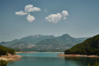 Scenic view of lake by mountains against sky