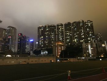 Illuminated buildings in city against sky at night