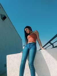 Full length portrait of woman standing against sky