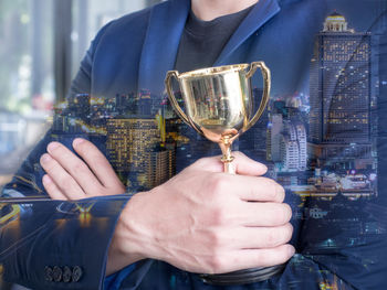 Midsection of man holding beer glass